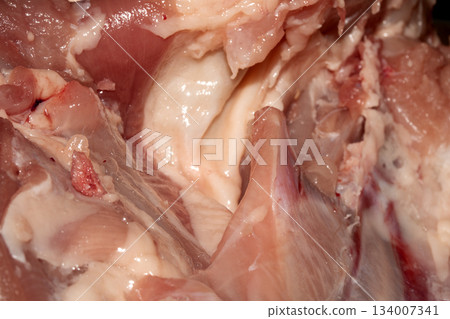 Close up of meat carcass tendons and bones from a chicken that has been carved horror blood red background food waste Close up of meat carcass tendons and bones from a chicken that has been carved horror blood red background food waste 134007341