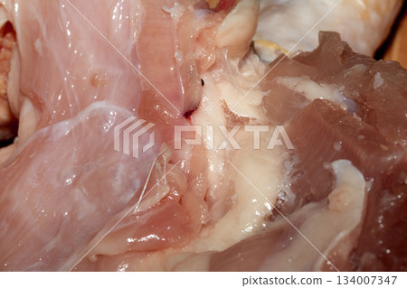 Close up of meat carcass tendons and bones from a chicken that has been carved horror blood red background food waste 134007347