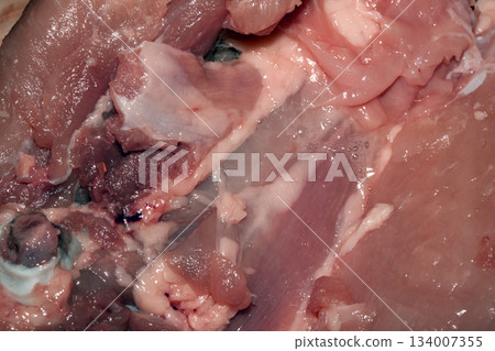 Close up of meat carcass tendons and bones from a chicken that has been carved horror blood red background food waste Close up of meat carcass tendons and bones from a chicken that has been carved horror blood red background food waste 134007355