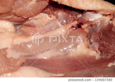 Close up of meat carcass tendons and bones from a chicken that has been carved horror blood red background food waste Close up of meat carcass tendons and bones from a chicken that has been carved horror blood red background food waste 134007360