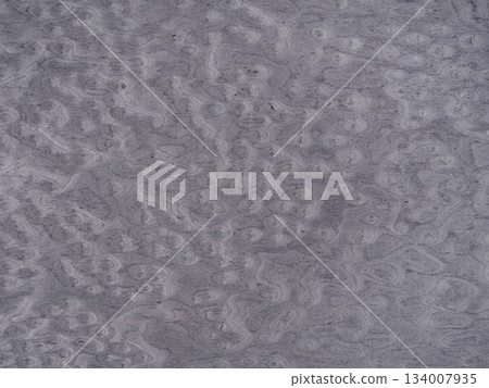 Swirling patterns on a muted gray veneer surface evoke a sense of organic movement Swirling patterns on a muted gray veneer surface evoke a sense of organic movement 134007935