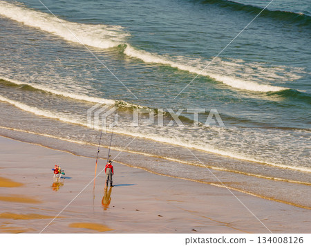 Angler with fishing rod on sea shore 134008126