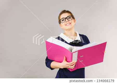 Happy positive business woman holding binder with documents Happy positive business woman holding binder with documents 134008179