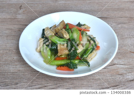 fried Kailaan Chinese kale and carrot with tofu dressing soy sauce vegetarian food on plate fried Kailaan Chinese kale and carrot with tofu dressing soy sauce vegetarian food on plate 134008386