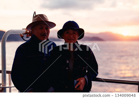 Portrait of a senior couple embracing each other on a boat at sunset Portrait of a senior couple embracing each other on a boat at sunset 134009048