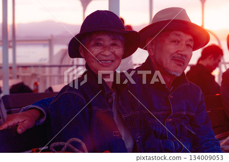Portrait of a senior couple embracing each other on a boat at sunset 134009053