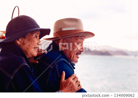 Portrait of a senior couple embracing each other on a boat at sunset Portrait of a senior couple embracing each other on a boat at sunset 134009062