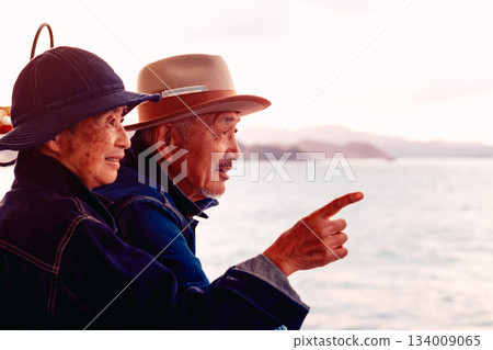 Portrait of a senior couple embracing each other on a boat at sunset 134009065