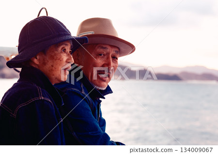Portrait of a senior couple embracing each other on a boat at sunset 134009067