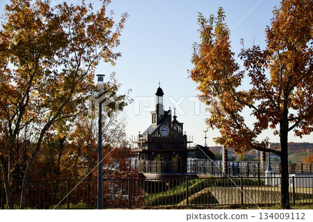 Ghibli Park's elevator tower reflected on the water surface Autumn scenery with autumn leaves Ghibli Park's elevator tower reflected on the water surface Autumn scenery with autumn leaves 134009112