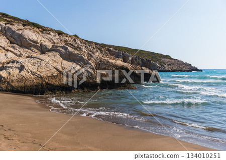 A tranquil coastal scene featuring rugged limestone cliffs. Patara beach landscape A tranquil coastal scene featuring rugged limestone cliffs. Patara beach landscape 134010251
