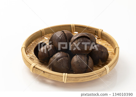 Roasted chestnuts served in a colander Roasted chestnuts served in a colander 134010390
