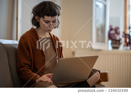 Concentrated teen girl working, studying at home in comfortable conditions using laptop computer 134010399
