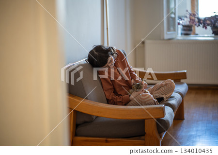 Depressed pet owner feeling lonely, stressed sitting at home with friend, companion cat devon rex Depressed pet owner feeling lonely, stressed sitting at home with friend, companion cat devon rex 134010435