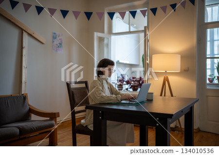 Pensive teenage girl spending time at home, using notebook, working as freelancer, studying online Pensive teenage girl spending time at home, using notebook, working as freelancer, studying online 134010536