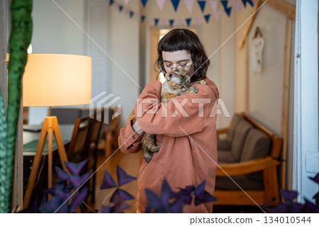 Woman adapting homeless pet cat petting holding in hands at home. Cat therapy Woman adapting homeless pet cat petting holding in hands at home. Cat therapy 134010544