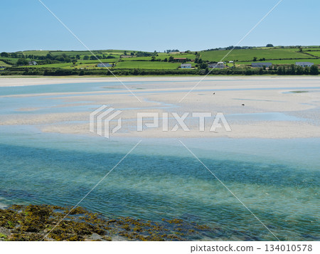 Beautiful view of a wide river near green hills on the horizon under white clouds. 134010578