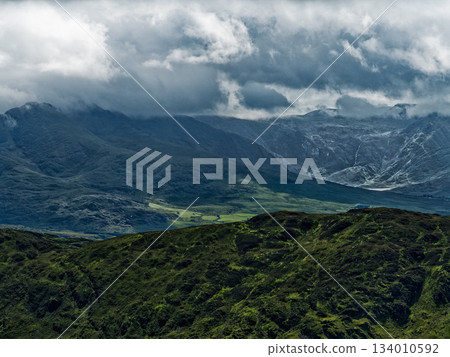 Coomloughra Horseshoe trail. Mountains tower in the background under moody skies, showcasing the rugged beauty of the Irish landscape. 134010592