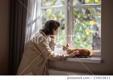 Outcast by friends teen girl feeling lonely, stresses, depressed stroking cat for emotional support  134010611