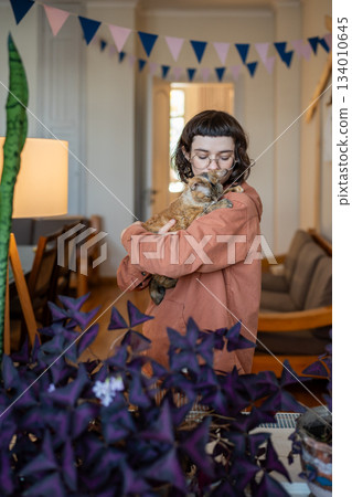 Woman adapting homeless pet cat petting holding in hands at home. Cat therapy 134010645