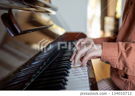Hands of woman professional pianist practicing music skills playing piano in conservatory. 134010712