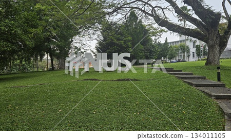 The #NUS sculpture stands beside a tree-lined slope and academic serenity in a scenic outdoor space at the National University of Singapore. The #NUS sculpture stands beside a tree-lined slope and academic serenity in a scenic outdoor space at the National University of Singapore. 134011105