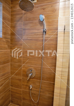 Modern shower interior with wood-look tile and dual fixtures. Modern shower interior with wood-look tile and dual fixtures. 134012615