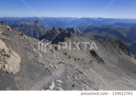 Hikers make their way along the trail to Schesaplana in Vorarlberg, Austria during a sunny day iHikers make their way along the trail to Schesaplana in Vorarlberg, Austria during a sunny day in the Hikers make their way along the trail to Schesaplana in Vorarlberg, Austria during a sunny day iHikers make their way along the trail to Schesaplana in Vorarlberg, Austria during a sunny day in the 134012761