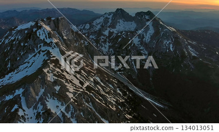 Rocky snow mountains at sunset aerial Rocky snow mountains at sunset aerial 134013051