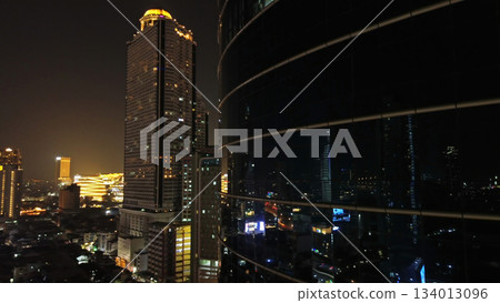 Skycrapper with reflection in glass busy traffic at night 134013096