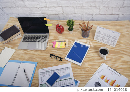Meeting room Office laptop business financial document chart , graph on wooden table with coffee cup. Flat lay notebook computer laptop on office desk. No people business graph chart on meeting table 134014018