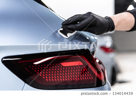 Ceramic coating application on blue car body near taillight during professional car detailing process Ceramic coating application on blue car body near taillight during professional car detailing process 134014439