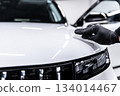 Ceramic coating application on white car hood and front panel during professional car detailing 134014467