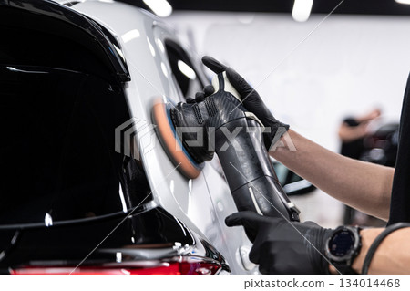 Ceramic coating application on black car rear body panel during professional car detailing Ceramic coating application on black car rear body panel during professional car detailing 134014468