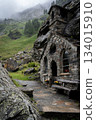 Vertical shot of stone chapel built into rock massif during moody cloudy rainy day, Austrian Alps 134015910