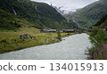Alpine village scenery with glacial river flowing through and massive glacier above, Austrian Alps 134015913