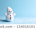 Cute snowman figure with a warm smile and cozy hat, set against a light blue background to celebrate winter festivities during the holiday season 134016101