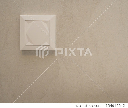 Close-up view of a modern white wall switch installed on a smooth beige wall. Minimalistic and neutral design fits themes of interior details, home renovation, electrical components, and contemporary Close-up view of a modern white wall switch installed on a smooth beige wall. Minimalistic and neutral design fits themes of interior details, home renovation, electrical components, and contemporary 134016642
