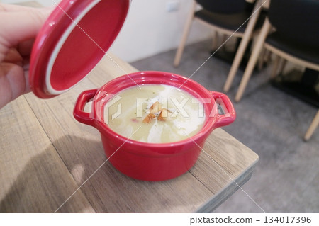 Creamy soup served in a red bowl with toasted bread cubes Creamy soup served in a red bowl with toasted bread cubes 134017396