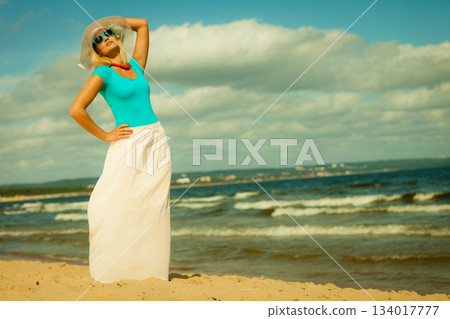 Beautiful blonde girl in hat on beach, summertime Beautiful blonde girl in hat on beach, summertime 134017777