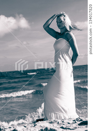 Beautiful woman on sunny beach. 134017820