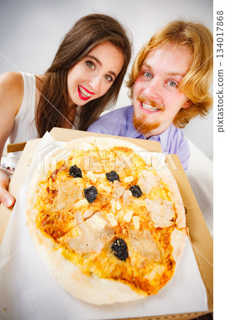 Funny couple eating pizza 134017868