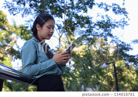 Female Employee Using Phone Outside Office Building. Female Employee Using Phone Outside Office Building. 134018781