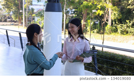 Two Young Asian Businesswomen Shaking Hands Outdoors. 134019080