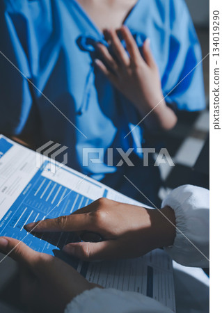 healthy concept; Doctor checking patient's heart with stethoscope at a hospital healthy concept; Doctor checking patient's heart with stethoscope at a hospital 134019290