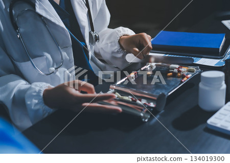 Female doctor holding a medicine bottle is checking the quality of medicine for any side effects the patient or not and recording patient information at the hospital. medical and health care concept Female doctor holding a medicine bottle is checking the quality of medicine for any side effects the patient or not and recording patient information at the hospital. medical and health care concept 134019300
