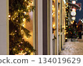 Christmas shop window decor. Street decorations for New Year. Glowing garlands and Christmas tree branches 134019629