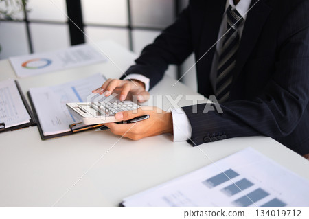 Businessman working in office calculating tax. Businessman working in office calculating tax. 134019712