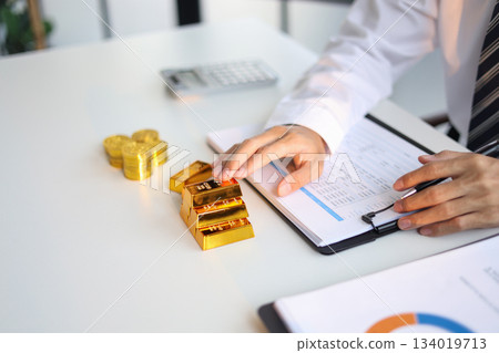 Gold Trading Businessman invest in trading gold, calculating profit price of buy and sell gold. Gold Trading Businessman invest in trading gold, calculating profit price of buy and sell gold. 134019713