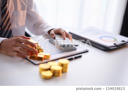 Businessman investing in gold to diversify portfolios hedge against inflation and currency depreciation. 134019813